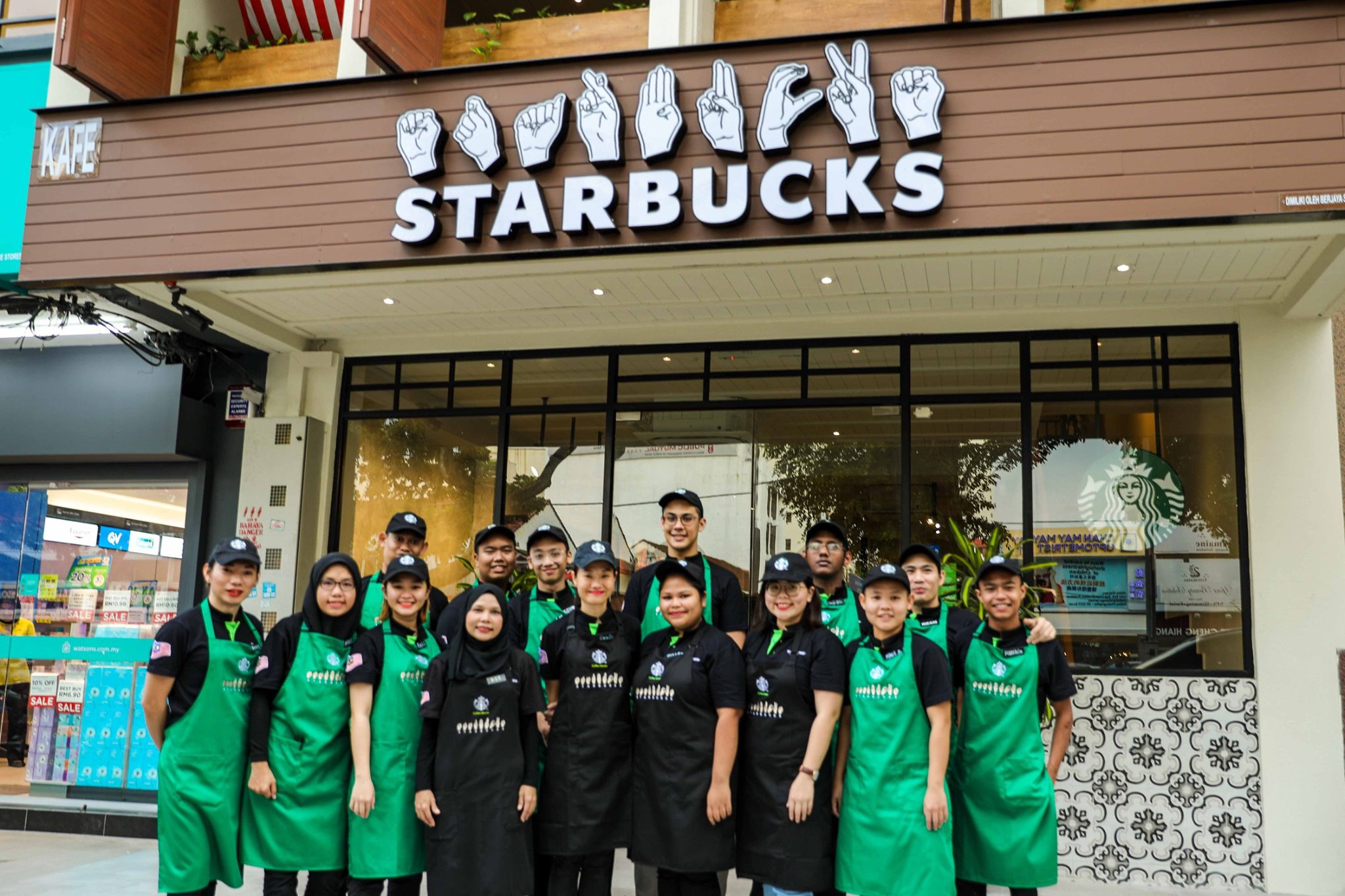 Starbucks staff posing outside the store