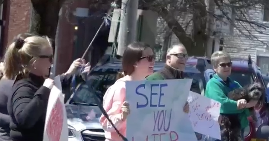 Friends hold up signs