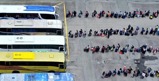 students lining up to get on buses during mco