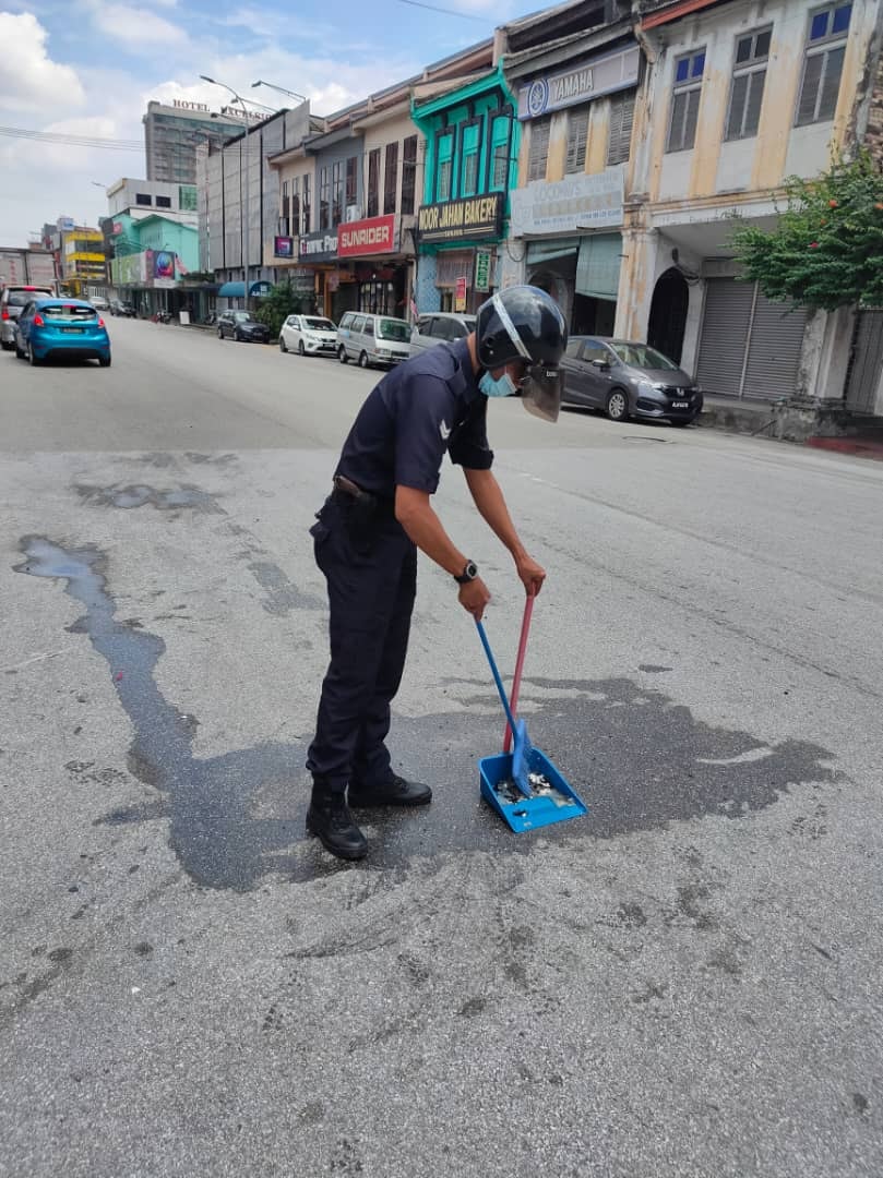 M'sian policeman sweeps car accident debris