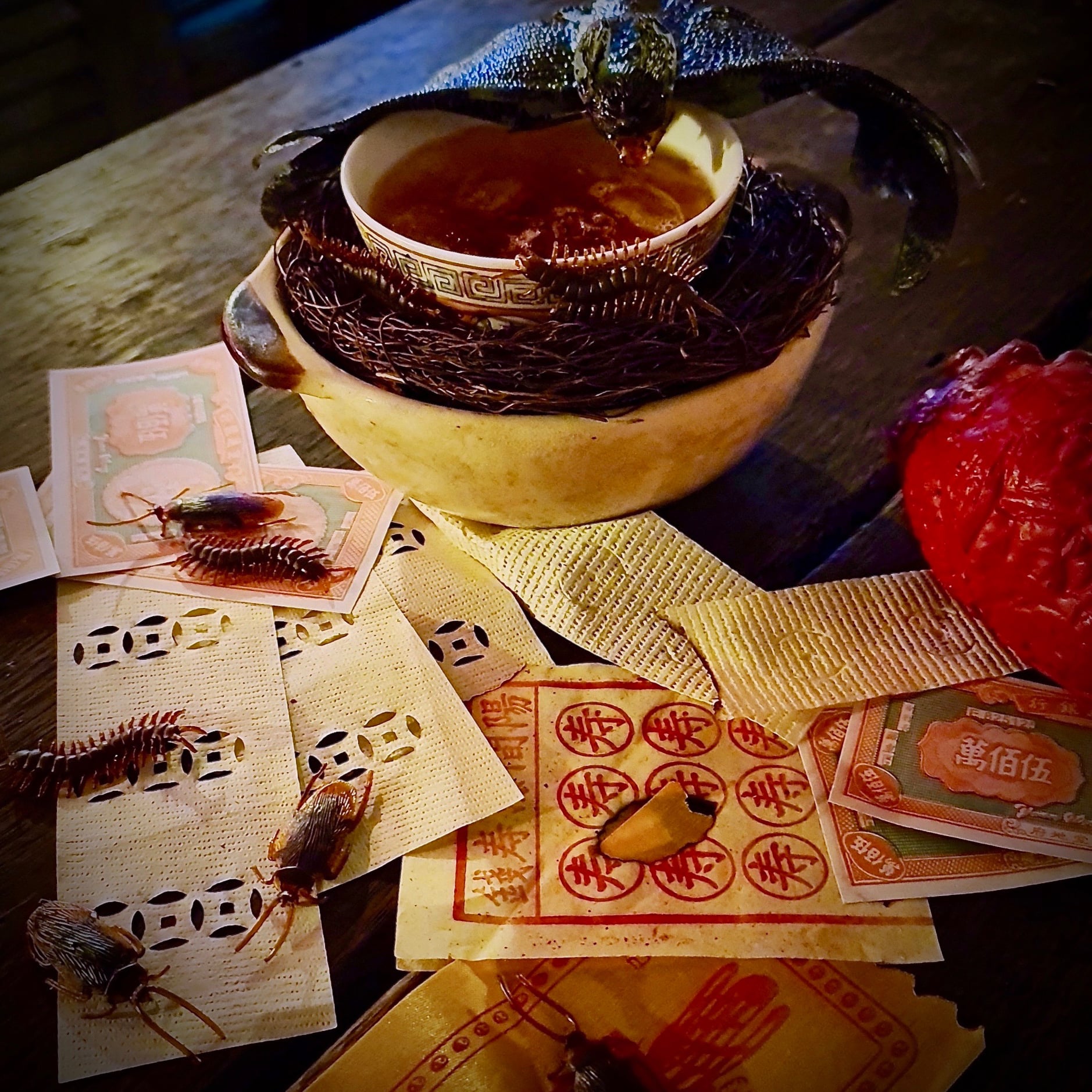 cocktail with chinese hell notes and cockroaches as props