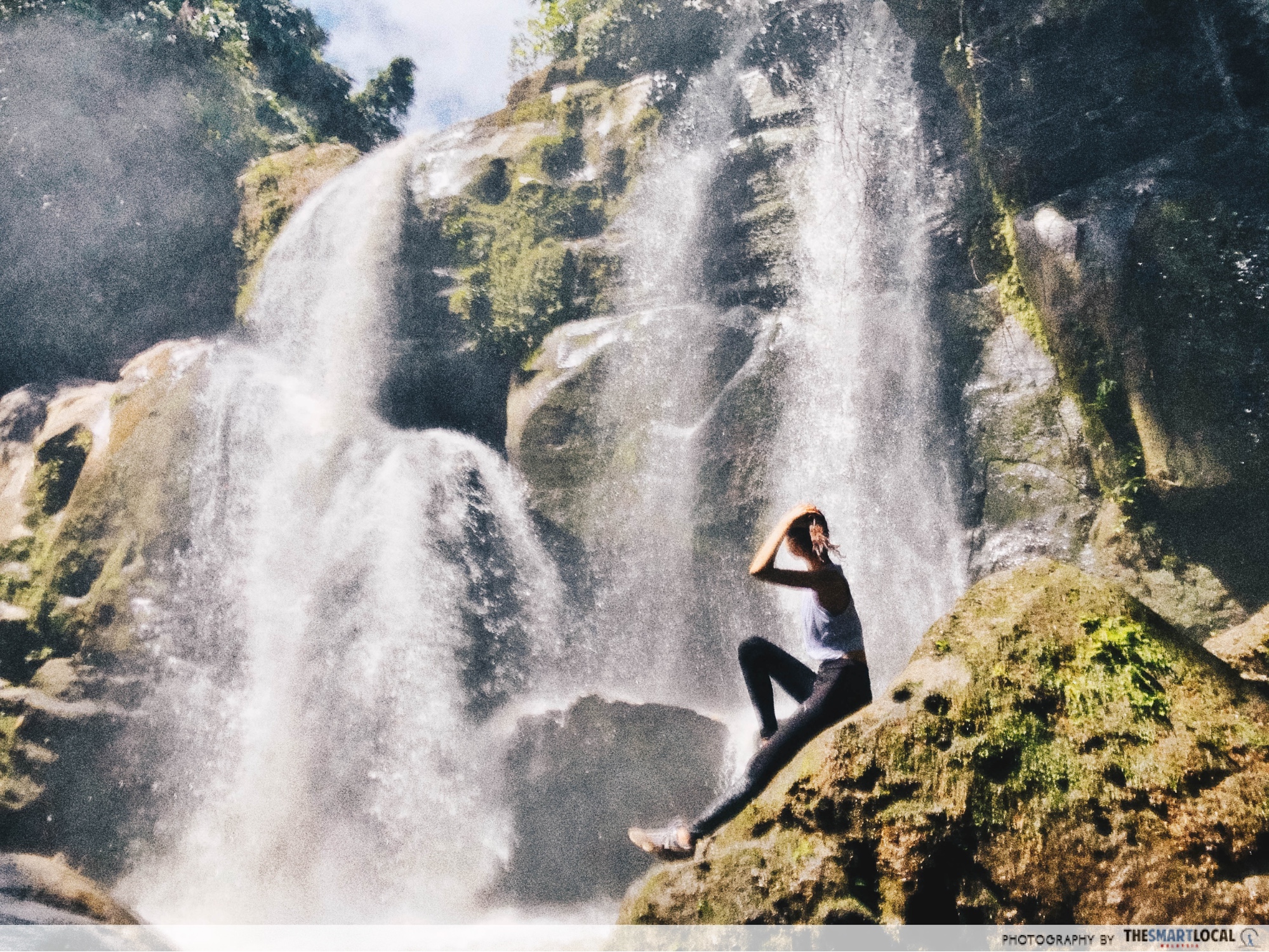 author posing in front of a waterfall