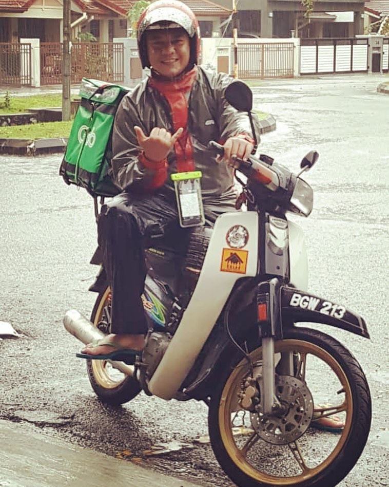 food delivery rider posing on his bike