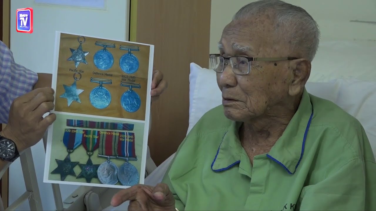 Tok Ujang showing his medals