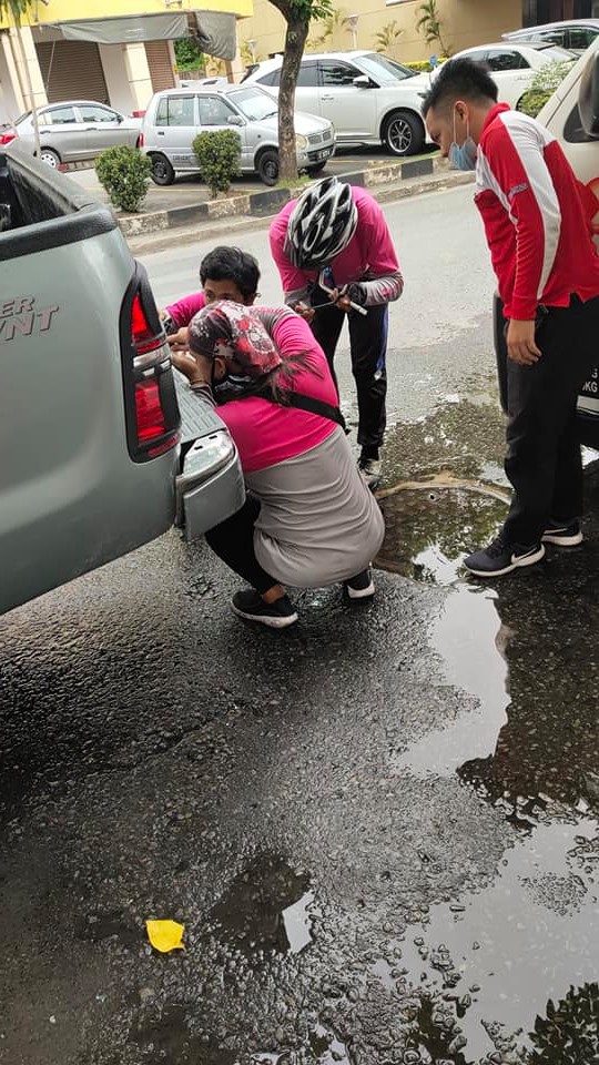 Foodpanda riders fixing punctured vehicle tyre on the road