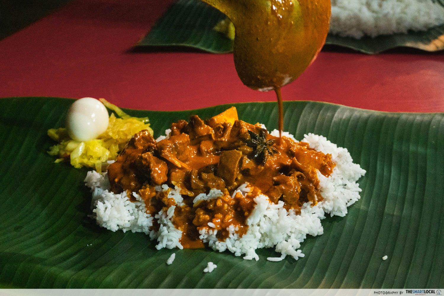 mutton curry is ladled onto white rice