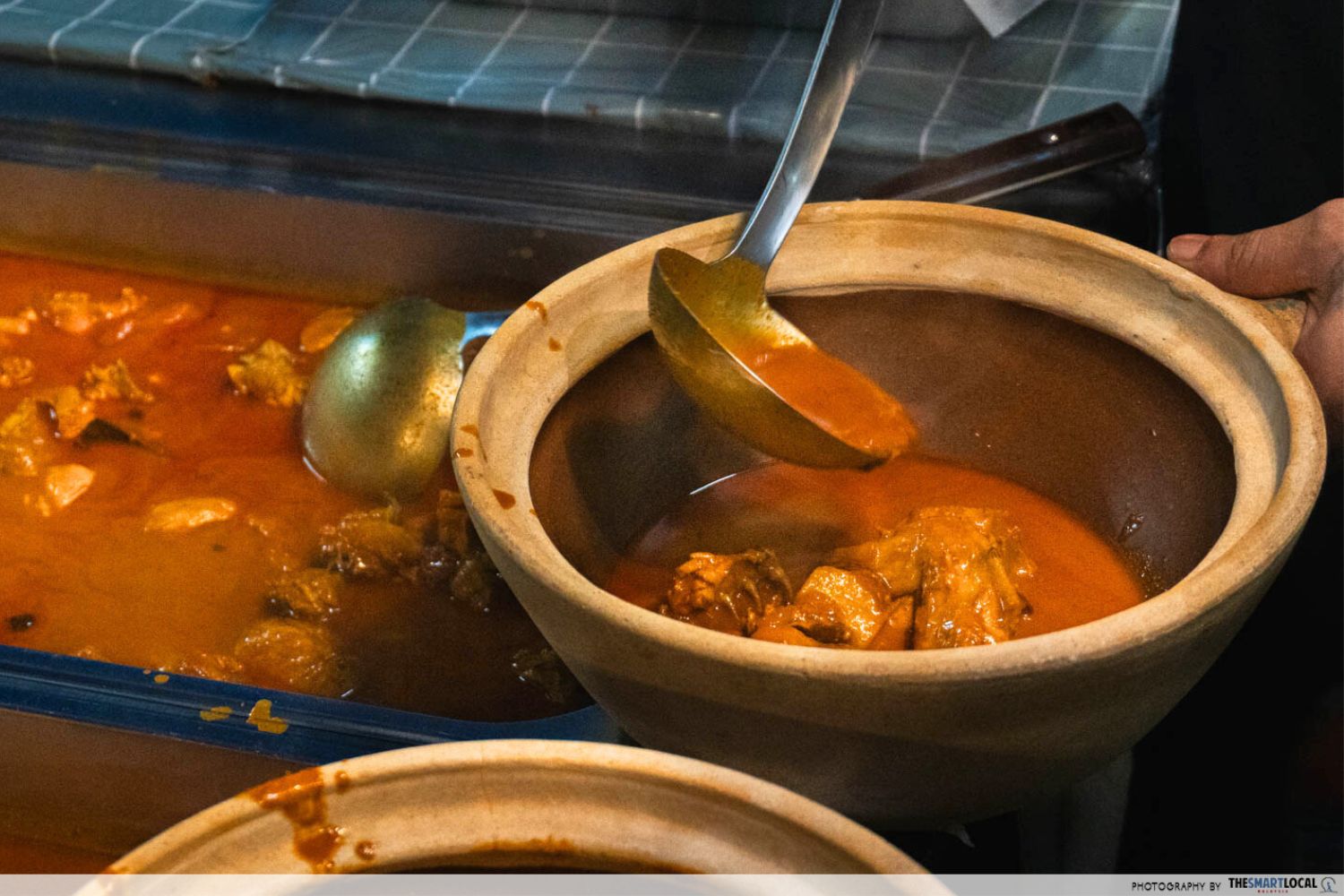 scooping curry into a claypot