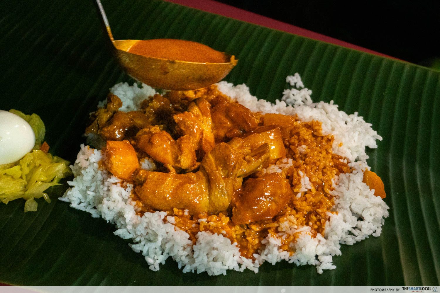chicken curry is ladled on top of white rice