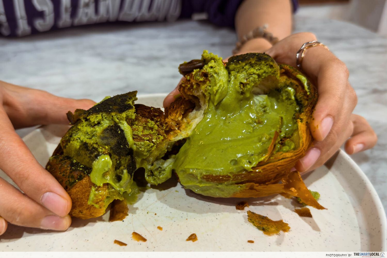 matcha yoghurt cheese oozes out of a cup-like croissant