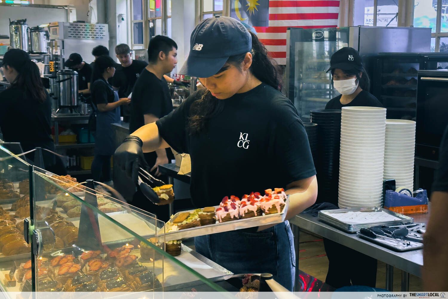 a staff putting pastries onto display