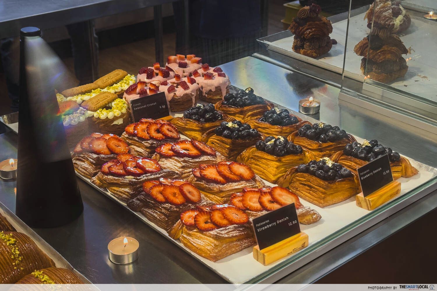 a display of danish pastries with strawberries and blueberries from KLCG