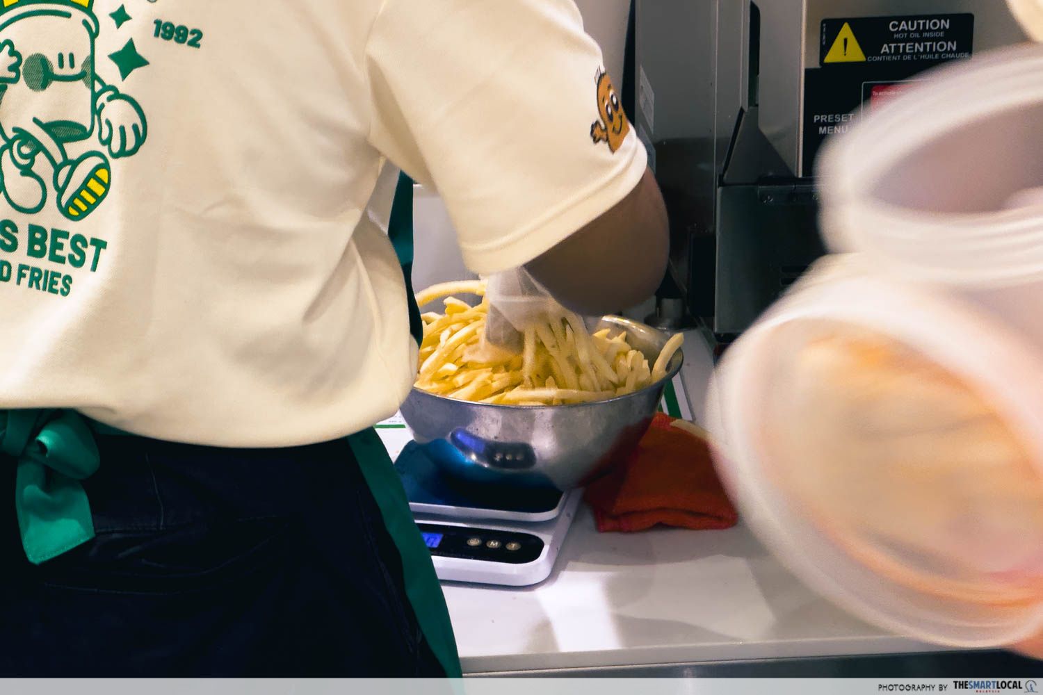 staff making fries in a stainless steel bowl