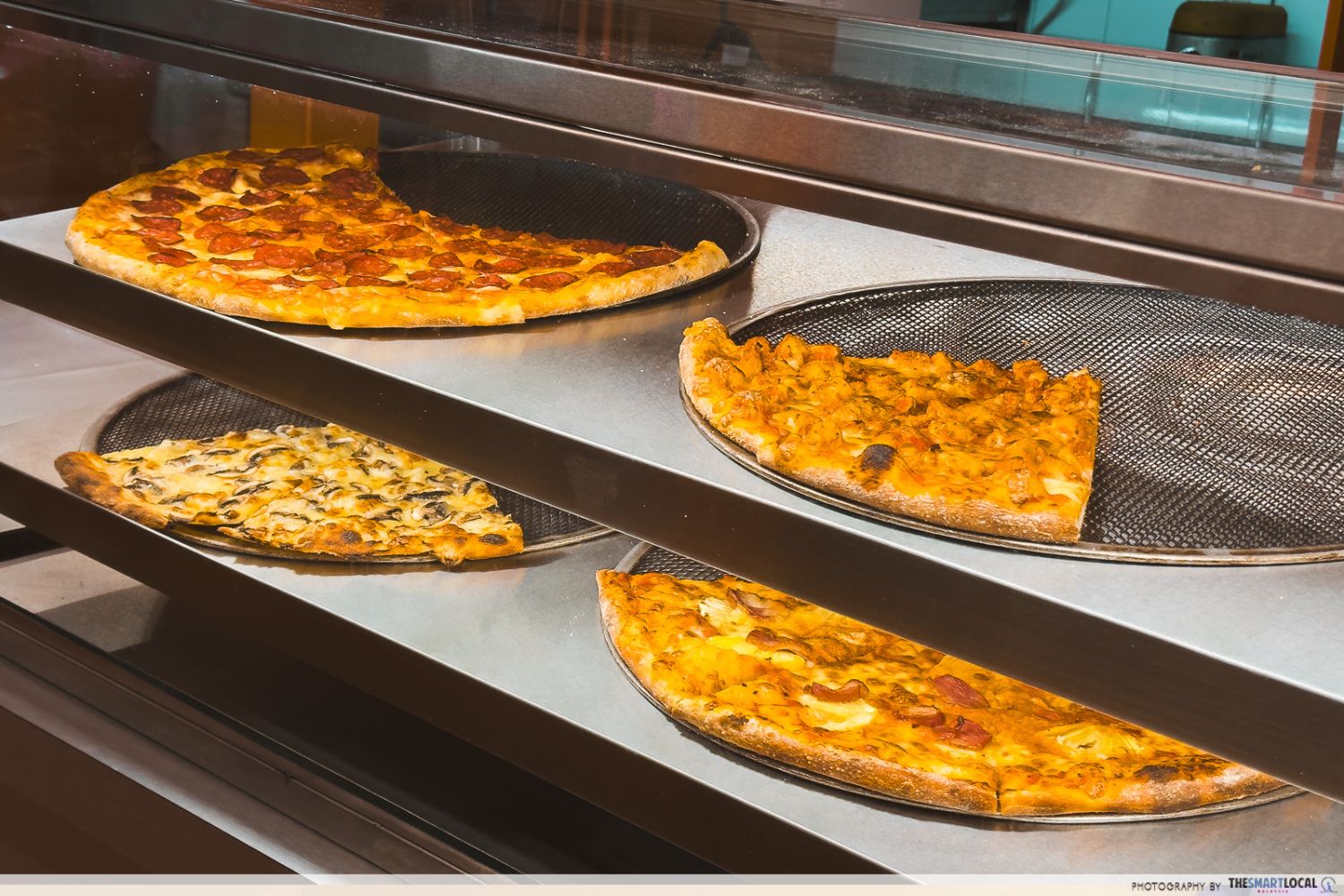 four flavours of new york-style pizzas cut into huge individual slices